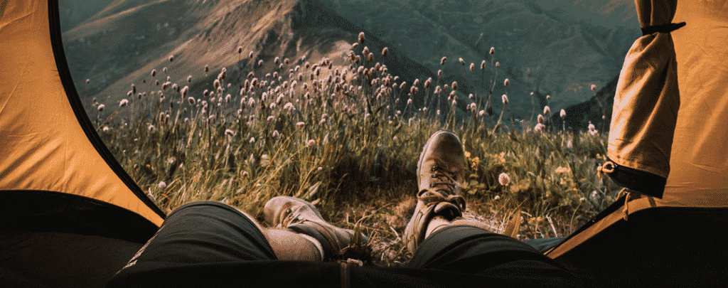 Un digital nomad campe en montagne et travaille à distance.