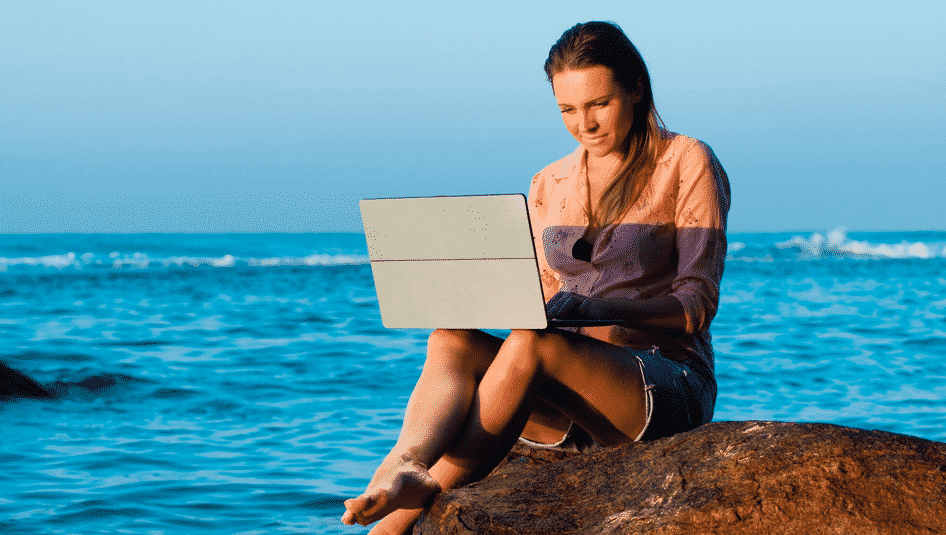 Une digital nomade est en train de travailler à la plage
