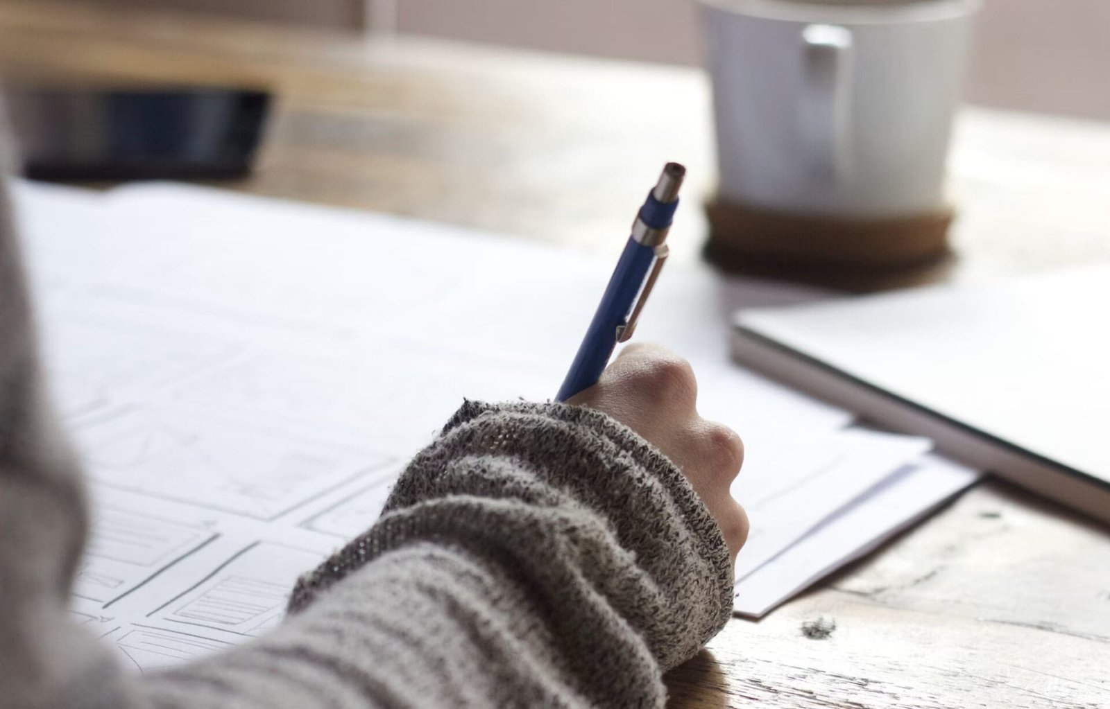 Un écrivain concentré, plume à la main, laisse ses idées se déployer sur le papier blanc.