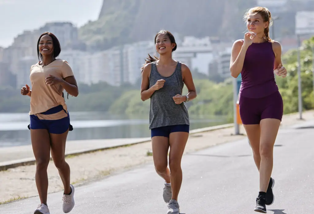 Marcher et gagner de l'argent - Les meilleurs applications 1 Trois femmes font du jogging dans une rue de Rio de Janeiro, utilisant les meilleures applications pour marcher et gagner de l'argent.