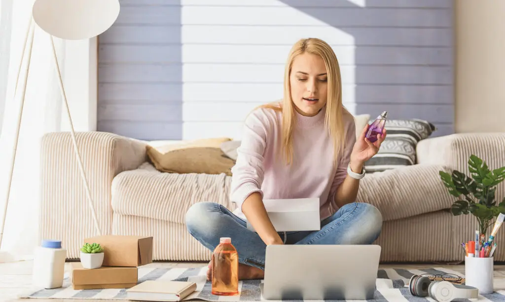 Créer son auto-entreprise - Tutoriel complet pour débutant 7 Une femme assise par terre avec un ordinateur portable et des cartons tout en suivant un tutoriel complet pour débutant pour créer son propre travail indépendant.