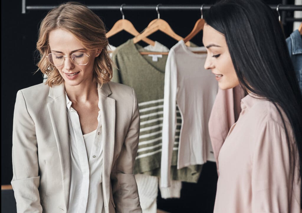 Deux femmes achètent des vêtements dans une salle d'exposition de vêtements.