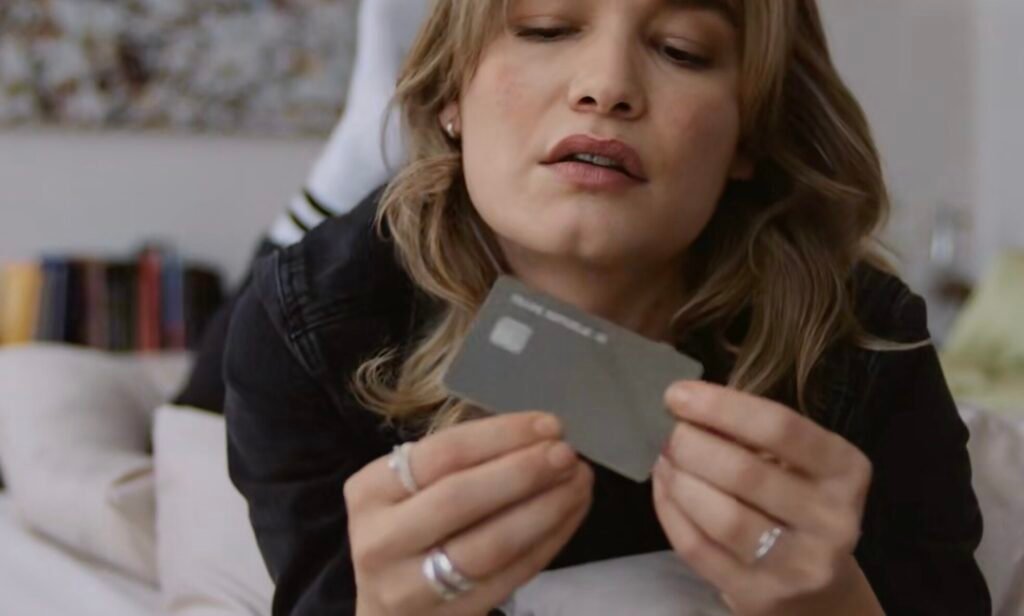 Trade Republic Avis : investissez, dépensez et épargnez facilement 5 Une femme tient en main la carte de trade repblic.