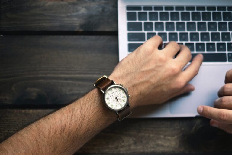 Les mains d'un homme sur un ordinateur portable utilisant la technique Pomodoro pour améliorer la productivité.