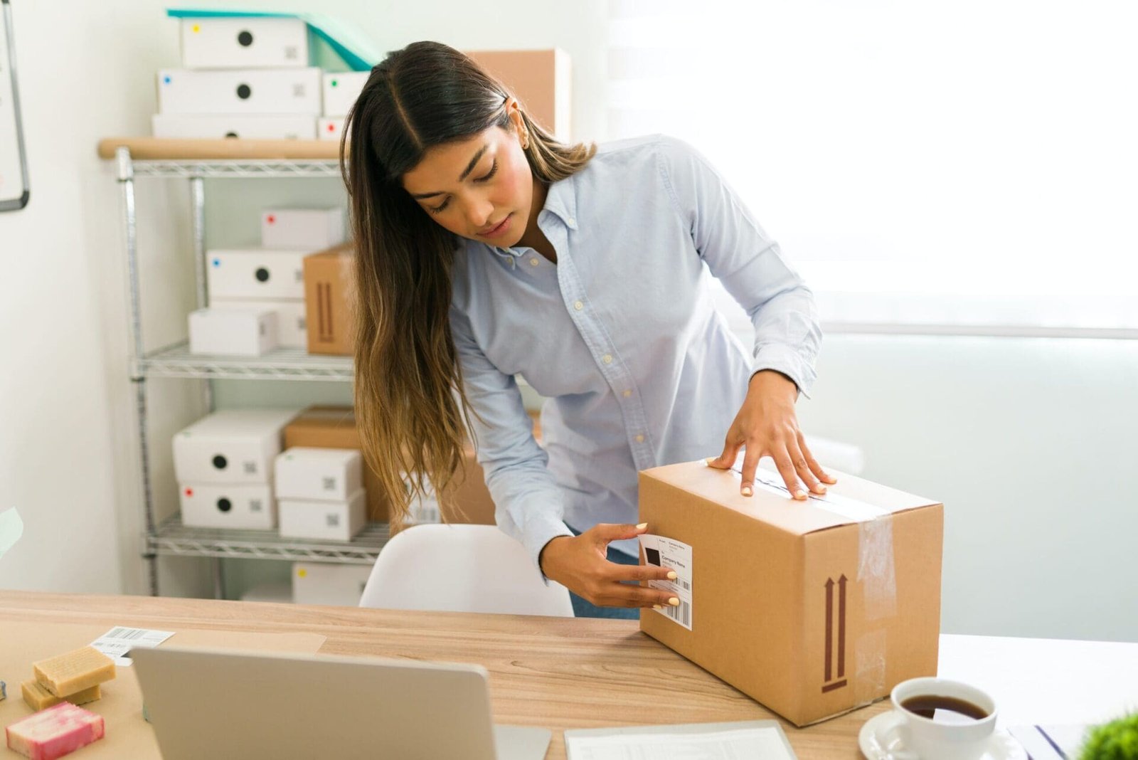 Une femme ouvre une boîte Cocolis dans son bureau.