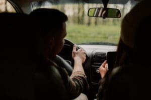 Un couple dans une voiture vérifiant son téléphone.