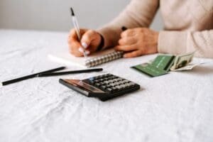Une femme calcule ses finances à une table.