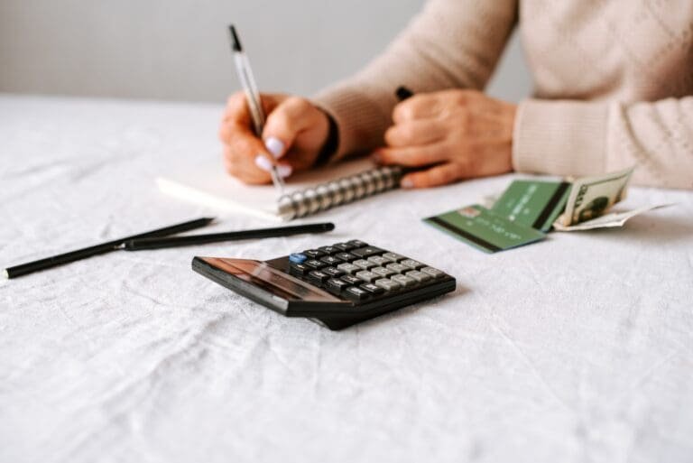 Une femme calcule ses finances à une table.