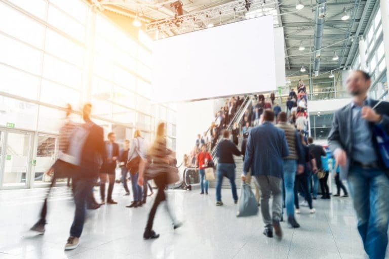 Évènements commerciaux : comment adapter la communication ? 1 Un groupe de personnes marchant dans un aéroport lors d’événements professionnels.
