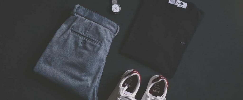 Des pantalons, chemises, chaussures et robes de fournisseurs en dropshipping sur fond noir.